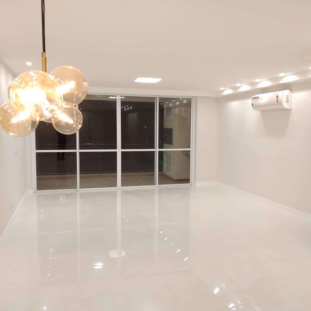 Ambiente residencial finalizado com piso porcelanato polido, esquadrias brancas, iluminação decorativa e ar-condicionado.