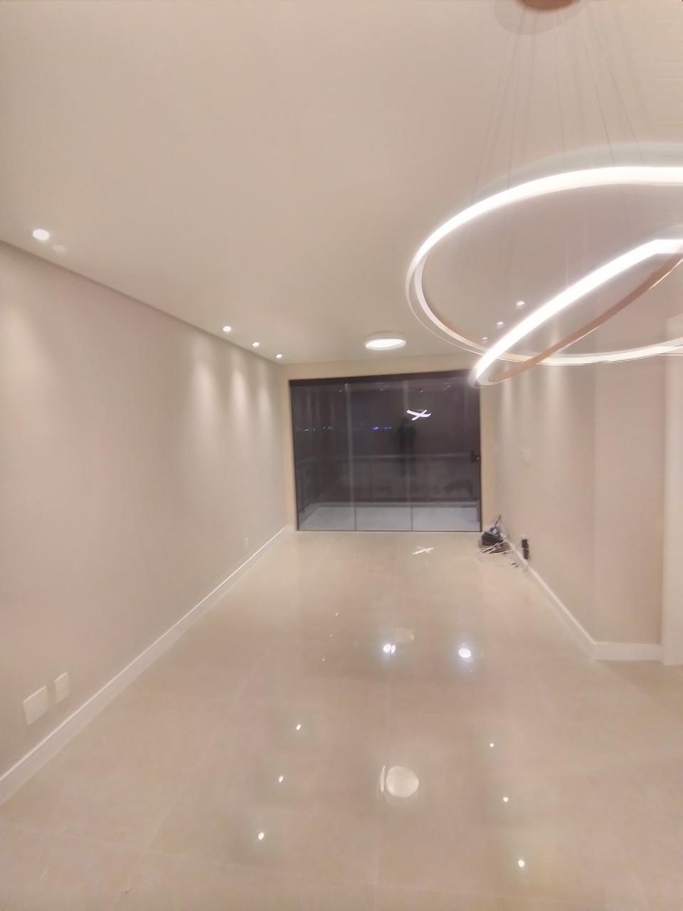 Sala de estar com piso porcelanato polido de alto brilho, lustre LED oval moderno e acabamento premium em forro e paredes