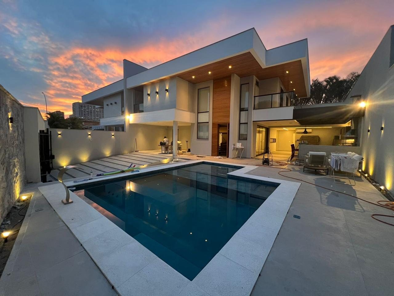 Residência de alto padrão entregue pela Eretz Construtora, com piscina e área externa integrada ao entardecer.